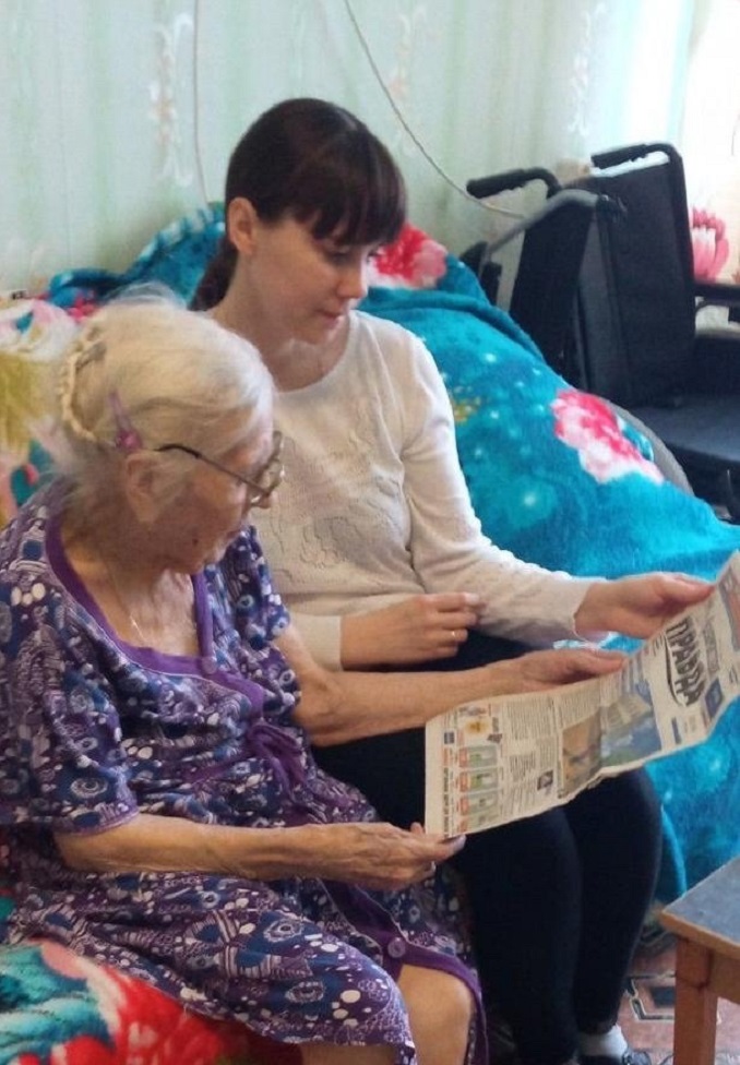 Сиделка Елена Борисова каждый день читает с Анной Ивановной газеты