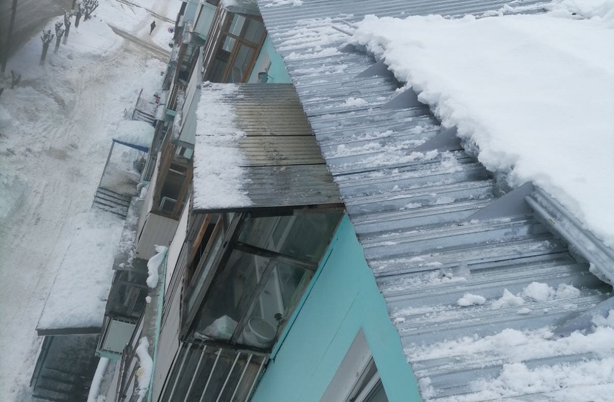 В Дзержинске ДУК очистил крышу дома после схода снега, который чуть не упал на женщину с ребенком