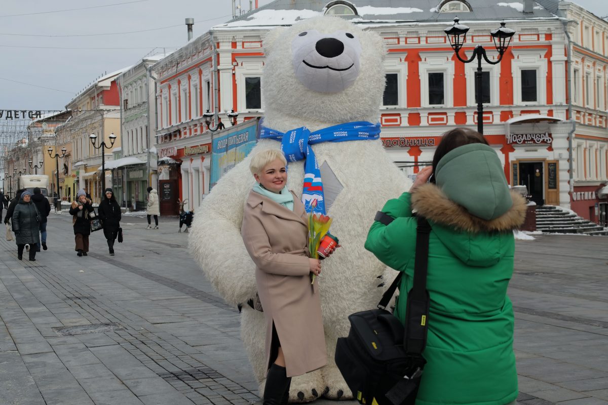 Волонтеры и большой белый медведь встречают нижегородок с цветами на Большой Покровской