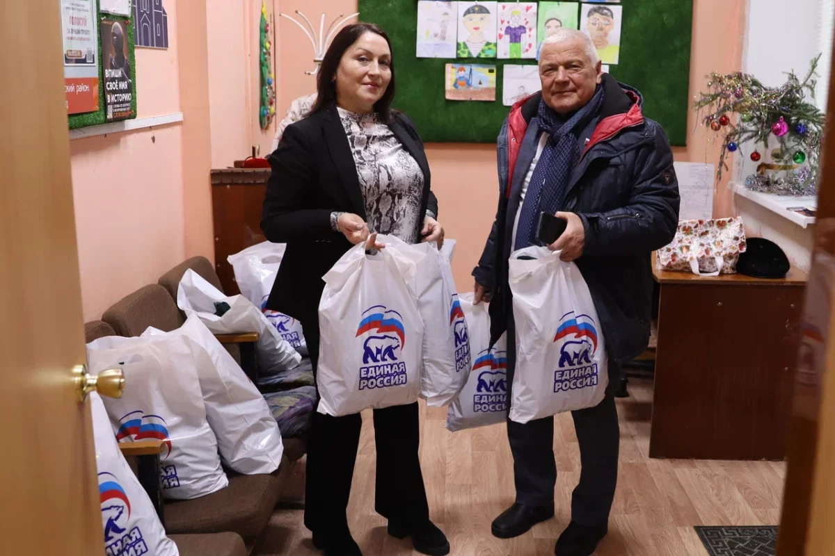Владимир Тарасов вместе с председателем ТОС 14 Мариной Беляевой разгружает привезённые им новогодние подарки для детей из малообеспеченных семей