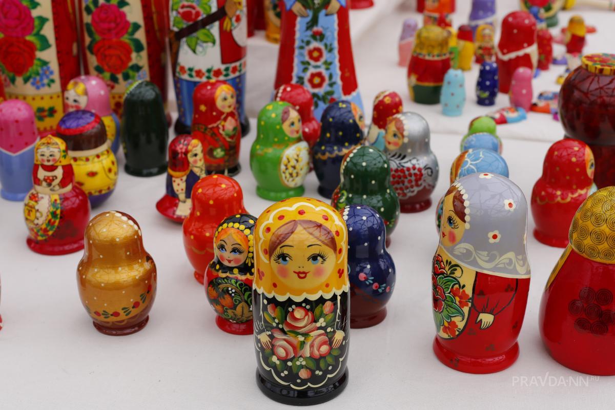 Туристы везут изделия с хохломской росписью, семёновскую матрёшку и ложки