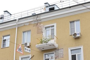 Рабочие укрепляют фундамент и стены дома в районе метро на улице Горького